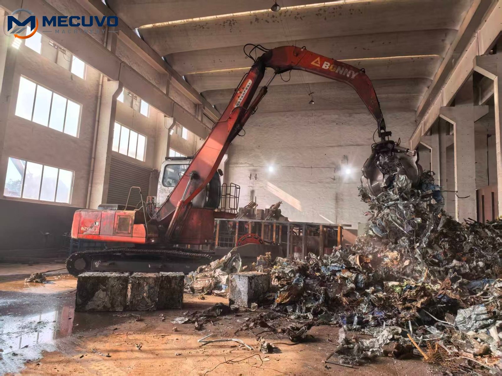 Large shredder working area in a scrap yard with material handling equipment Large industrial dual shaft shredder at a material processing site